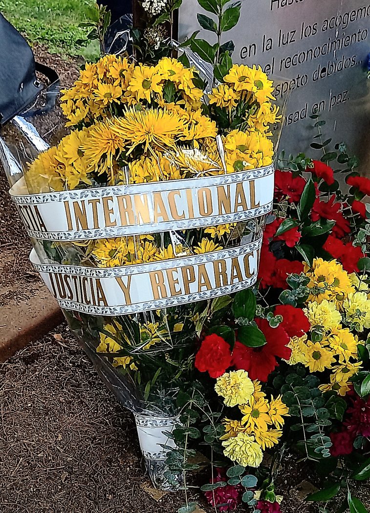 Ofrenda de flores. El ramo está envuelto en una cinta en la que puede leerse "Amnistía Internacional. Justicia y reparación".