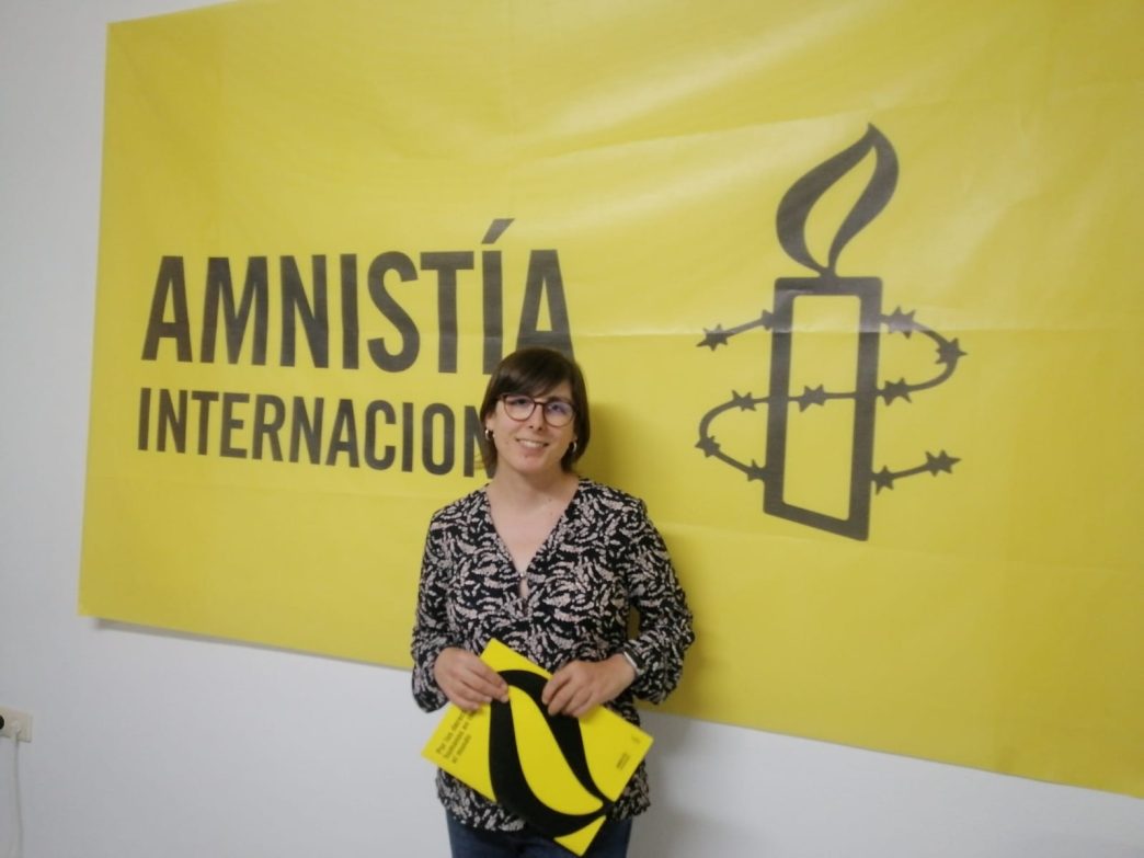 Marta León delante de un cartel de Amnistía Internacional
