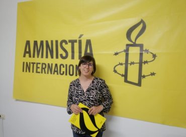 Marta León delante de un cartel de Amnistía Internacional