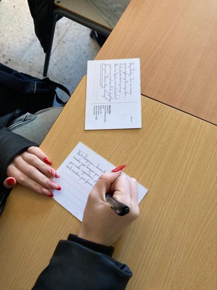 Dos manos escribiendo tarjetas postales