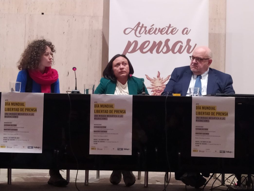 De izquiera a derecha: la presentadora Silvia Arjona, la periodista Maryórit Guevara y el director de Amnistía Internacional España, Esteban Beltrán, en una mesa. Tras la mesa cuelga un cartel con el lema "Atrévete a pensar".