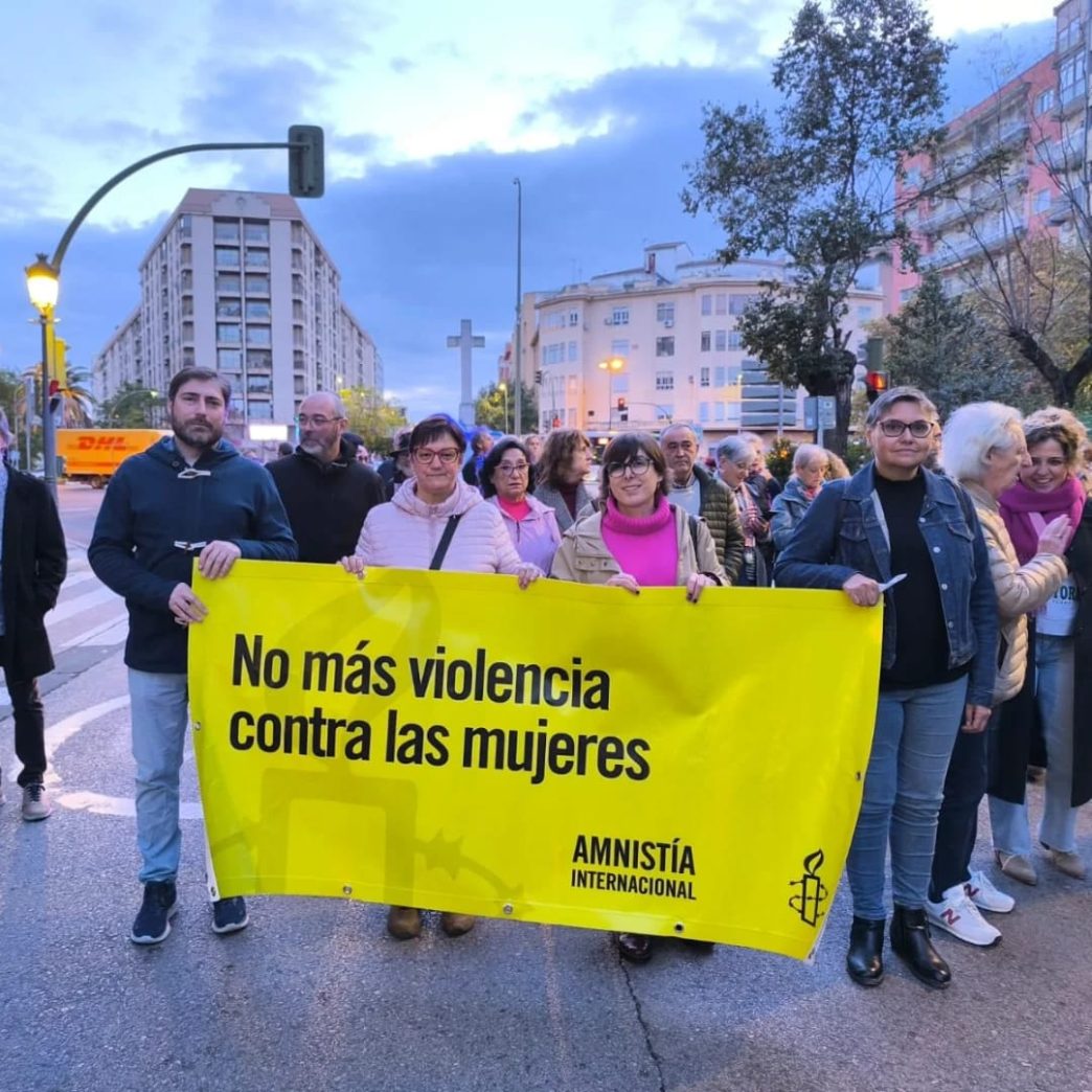 Activistas de AI, portando una pancarta con el lema NO MÁS VIOLENCIA CONTRA LAS MUJERES, en el centro de Cáceres.