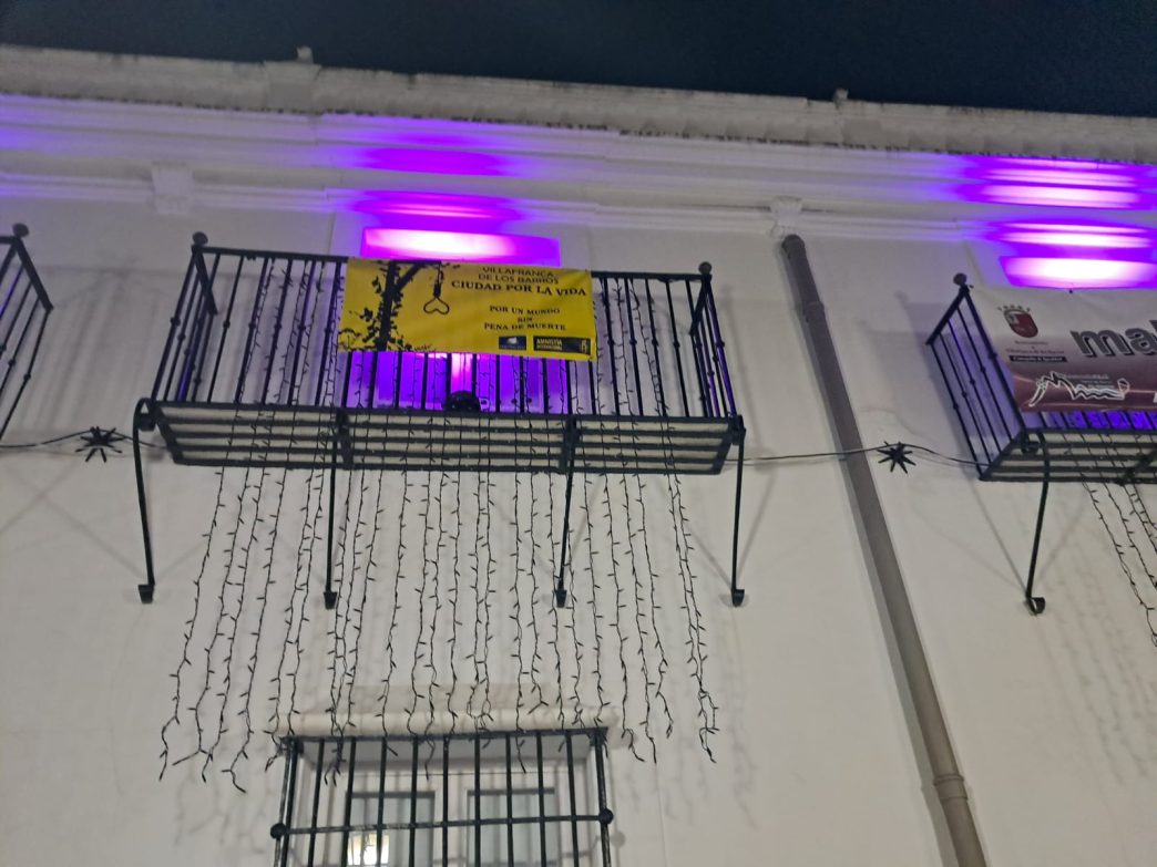 Balcón iluminado de morado en Villafranca de los Barros, con una pancarta con el texto VILLAFRANCA DE LOS BARROS CIUDAD POR LA VIDA
POR UN MUNDO SIN PENA DE MUERTE