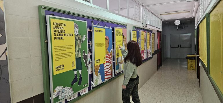 Una alumna viendo la exposición en un pasillo.