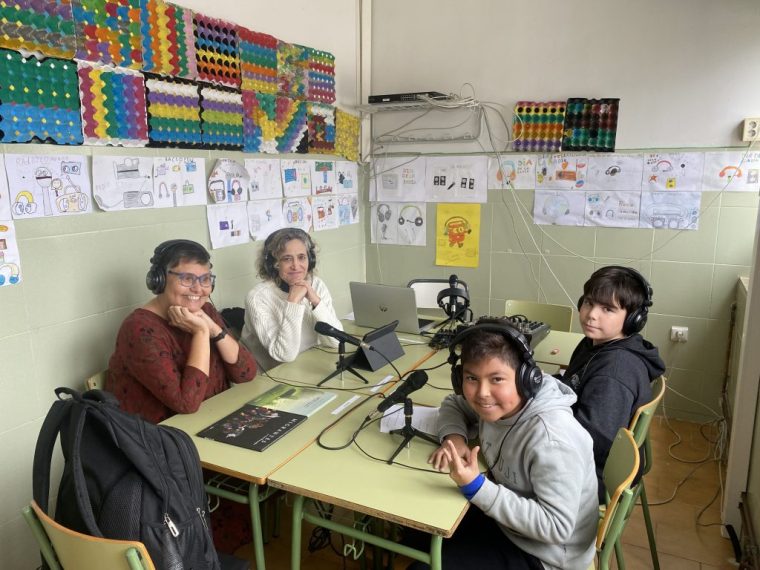 Nuestras compañeras de AI y los alumnos entrevistadores, en torno a una mesa en el estudio de radio.