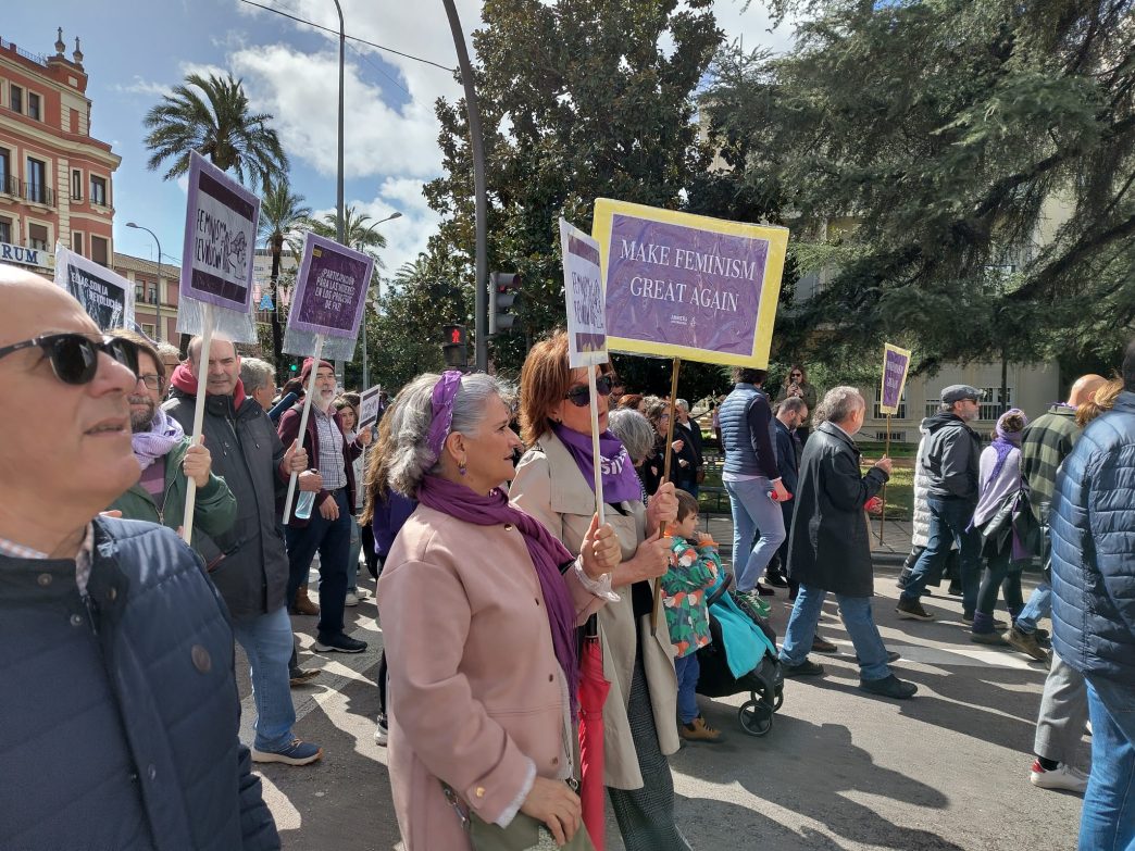 Marcha del 8 M en Badajoz. Se ven activistas de AI portando pancartas. En una de ellas se lee el lema MAKE FEMINISM GREAT AGAIN.