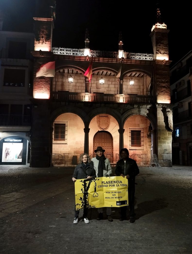 Activistas de Amnistía Internacional, ante el Ayuntamiento de Plasencia, con un cartel con el lema PLASENCIA CIUDAD POR LA VIDA.