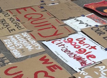 Pancartas de cartón con lemas sobre equidad, unidad y solidaridad