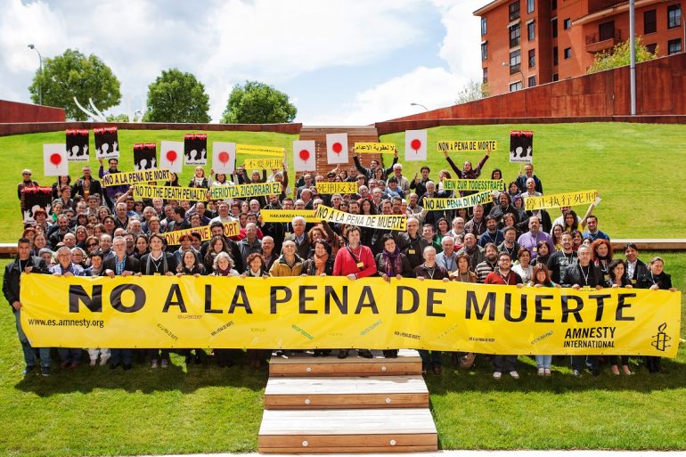 Un numeroso grupo de activistas de Amnistía Internacional portan una pancarta que reza 'no a la pena de muerte'